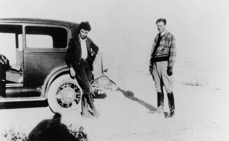 Robert Oppenheimer (left) and Ernest Lawrence  at Oppenheimer’s New Mexico ranch, Perro Caliente (“hot dog”). The car may be a 1930 Chrysler 77 Crown Coupe. Photo courtesy of the AIP Emilio Segrè Visual Archives.