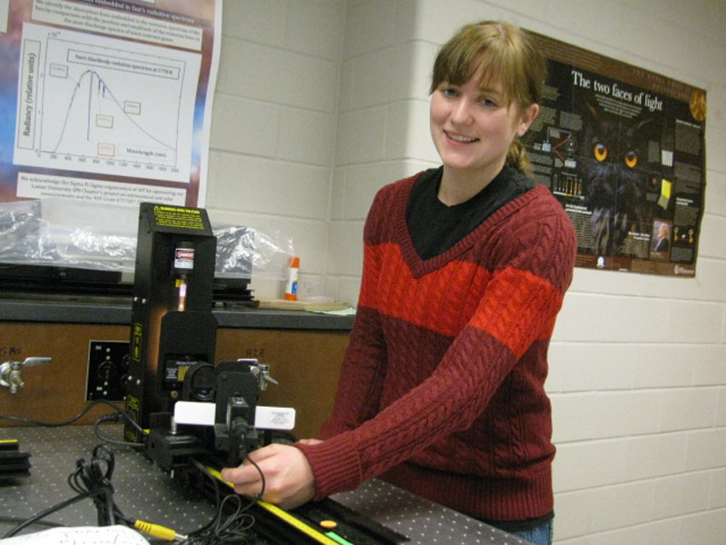 The author poses with the atomic spectroscopy setup in  Lamar University’s optics lab.