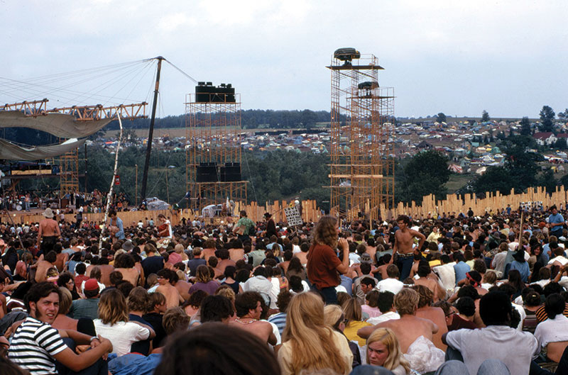 Woodstock, a music and art festival held in August of 1969, attracted more than half a million people and featured iconic performances by Richie Havens, Jefferson Airplane, Jimi Hendrix, Janis Joplin, and many others. In this photo the stage is on the left and the camping area is in the distance. The towers were for light and sound. Photo by Woodstock Whisperer, licensed under CC BY-SA 4.0.