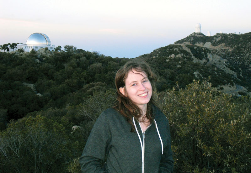 The author poses for a photo with the MDM Observatory (left) and Kitt Peak National Observatory (right). Photo courtesy of  Rachael Roettenbacher.