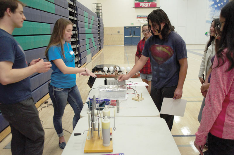 acob Wikowsky and Lindsey Hart show a student the mini-plasma cutter made from a voltage supply, pencil lead, and aluminum foil. Photo by Allison Tucker.