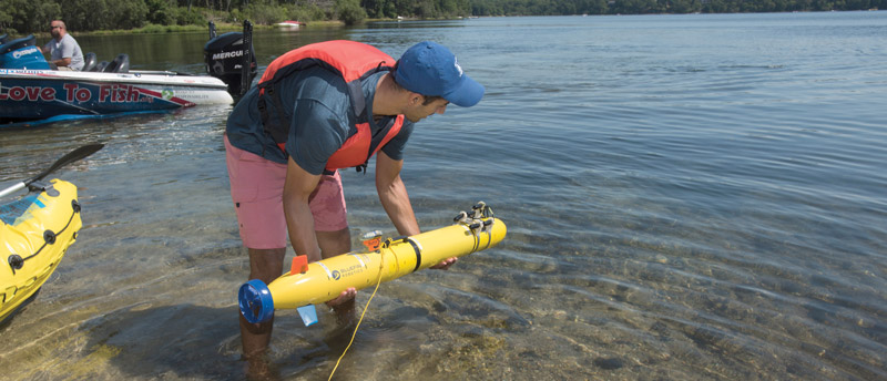 Bhatt testing an autonomous underwater vehicle at Ashumet Pond in East Falmouth, Massachusetts. Photo by Tom Kleindinst. © Woods Hole Oceanographic Institution.