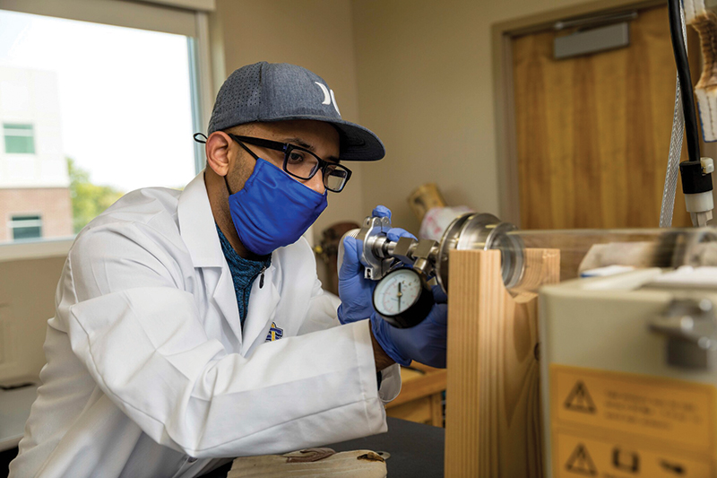 Abdullah Al Maruf works with a plasma annealing chamber to create a thin film coating of PLNM on the lithium anode. Photo courtesy of SDSU.