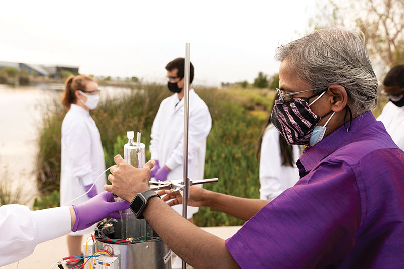 SPS faculty advisor Professor Sesha Srinivasan (right) supports the students in setting up the solar photocatalytic reactor at the FL Poly pond water site.