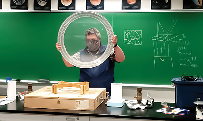 University of Alaska Fairbanks physics professor David Newman demonstrates quantum levitation to SPS members with a piece of yttrium-barium-copper oxide.