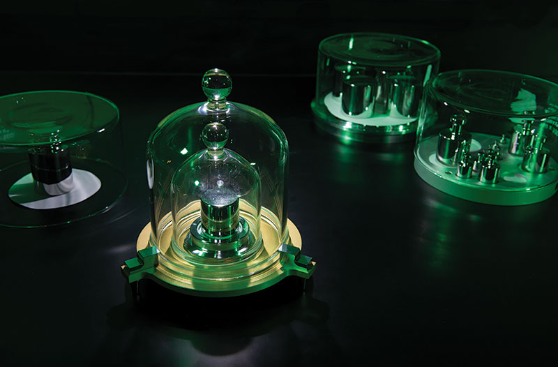 In 2018 the kilogram was redefined in terms of the Planck constant, ending our reliance on physical artifacts to define SI units. That transition was the subject of Bill Phillip’s talk. Shown here is a platinum-iridium kilogram mass housed at the National Institute for Standards and Technology (NIST), with stainless-steel masses in the background. Photo courtesy of J.L. Lee, NIST.