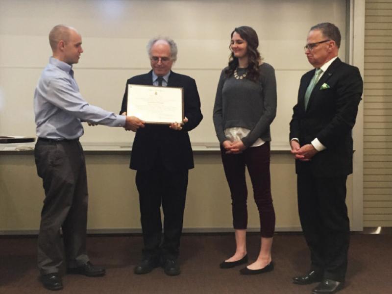 SPS director Brad Conrad presents the Sigma Pi Sigma charter to professor Elia Eschenazi, department chair at the University of the Sciences, as university president Professor Paul Katz and SPS president Katee O’Malley watch. Photo courtesy of Brad Conrad.