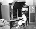 National Bureau of Standards (NBS) staff member sitting at the PILOT computer in 1961. Designed by NBS in 1958, this computer contained three independently programmed systems that could communicate and work together concurrently on a common problem. The PILOT has been called one of the earliest examples of multiprocessor computer architecture. Photo credit: National Institute of Standards and Technology Digital Archives, Gaithersburg, MD.